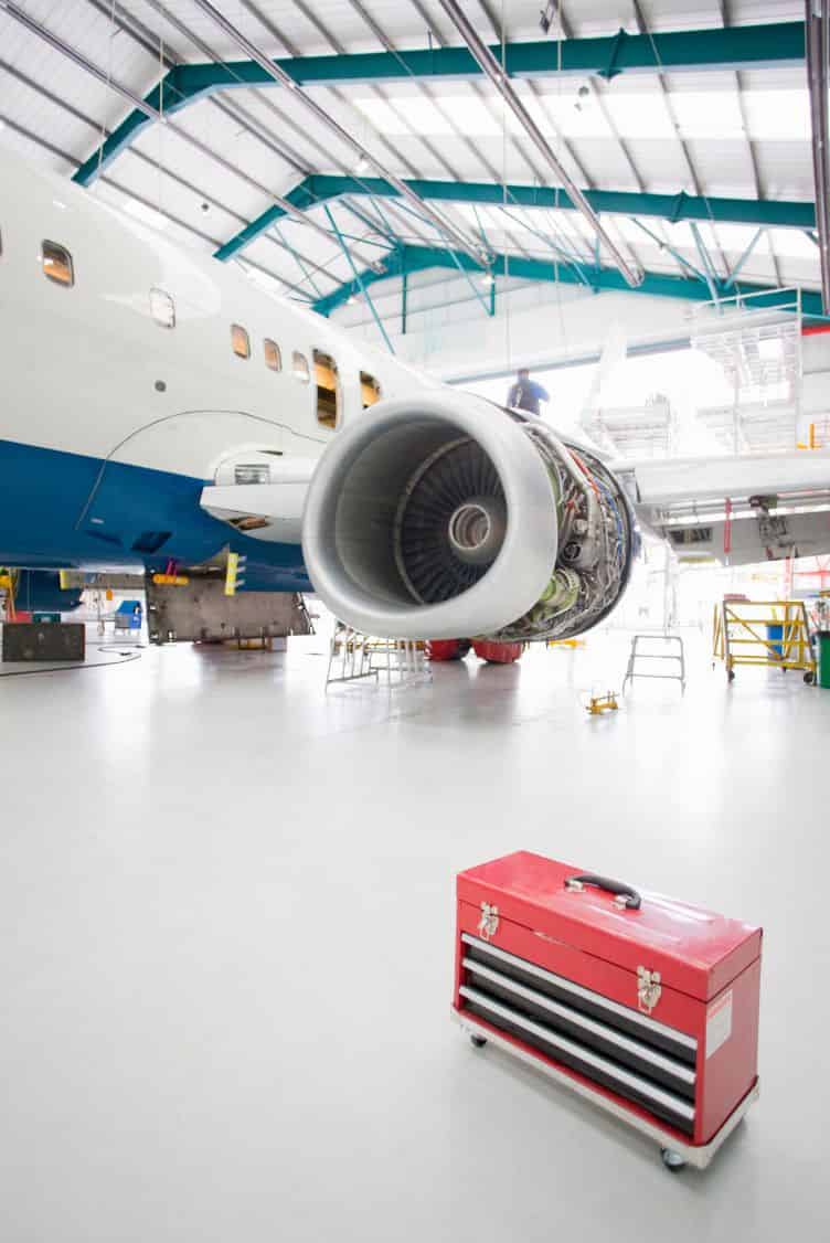 Seamless high-gloss resinous floor coating across a large clear-span aircraft hangar