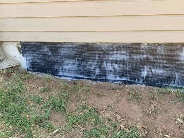 FRP fabric bonded to the masonry base of a wood-sided multifamily building exterior
