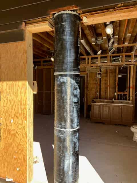Carbon fiber fabric wrapped around a structural concrete member during a seismic retrofit